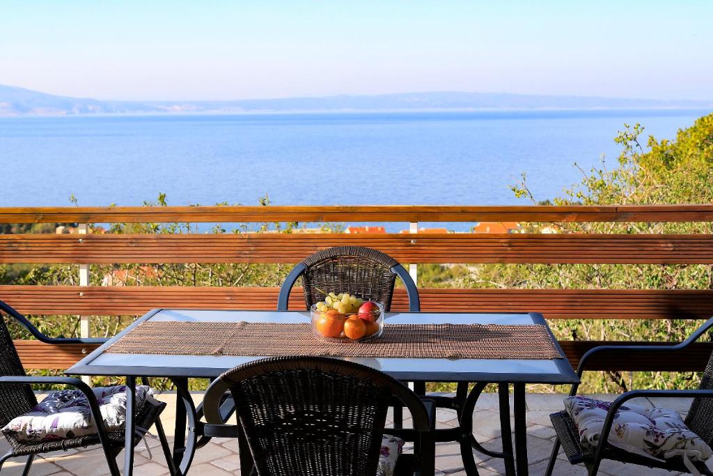 una mesa con un bol de fruta en el balcón en Apartment Vincent with beautiful sea view terrace, en Klenovica