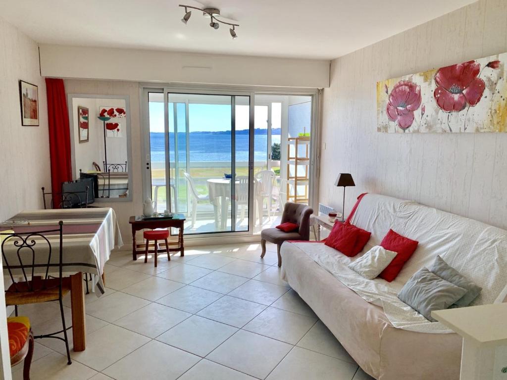 un salon avec un canapé et une vue sur l'océan dans l'établissement Appartement 3 étoiles avec belle vue sur mer à PERROS-GUIREC - ref 835, à Perros-Guirec
