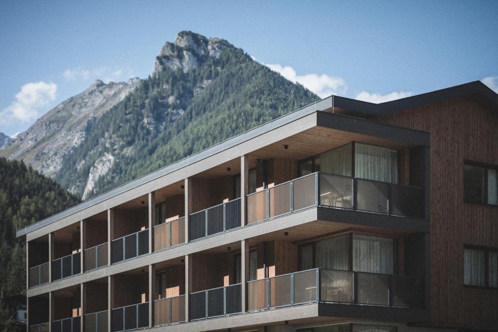 a building with a mountain in the background at Luxegg - Mountain Lodge in Lutago