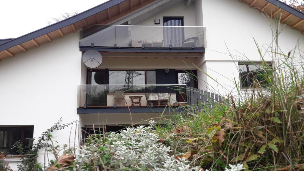 a white house with a balcony with chairs on it at RELAX in der Natur 2 Zimmer Apartment - im Grünen - Ruhelage in Kennelbach