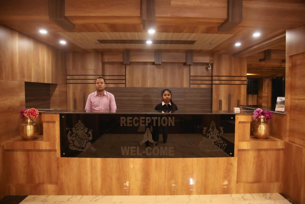 a man and woman standing at a reception desk at Hotel Royal Safari in Sauraha
