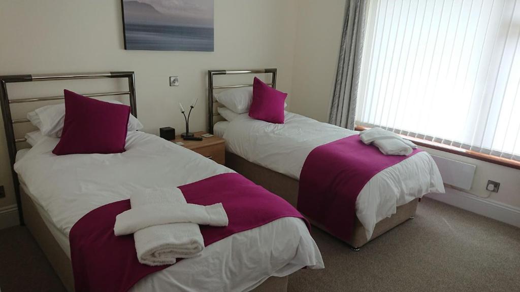 a bedroom with two beds with towels on them at Rose Vean Bed & Breakfast in Helston