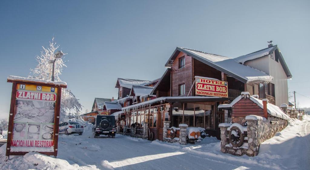 a snow covered street in a town with buildings at Hotel Zlatni bor in Žabljak