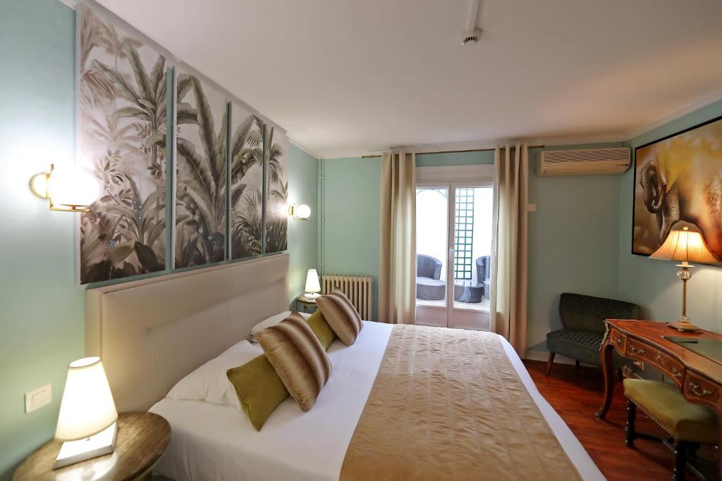 una camera d'albergo con un letto e una scrivania di Hotel Les Pasteliers ad Albi