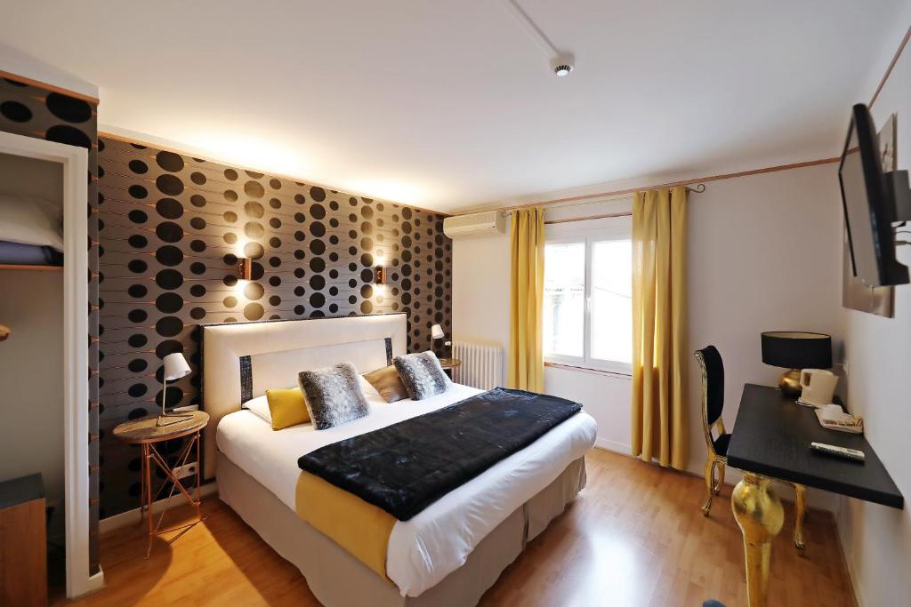 En eller flere senge i et værelse på Hotel Les Pasteliers