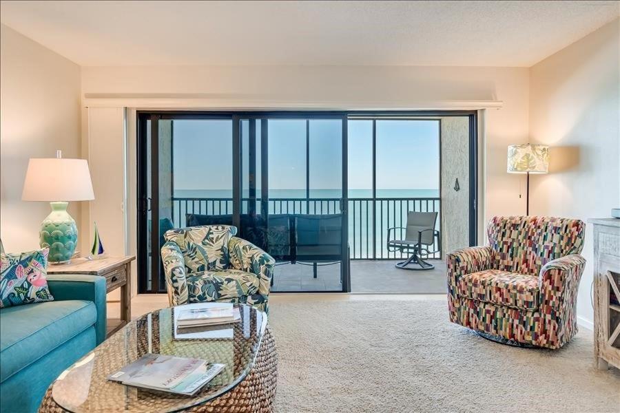a living room with a couch and chairs and a balcony at Sea Oats 215 Apartment in Boca Grande