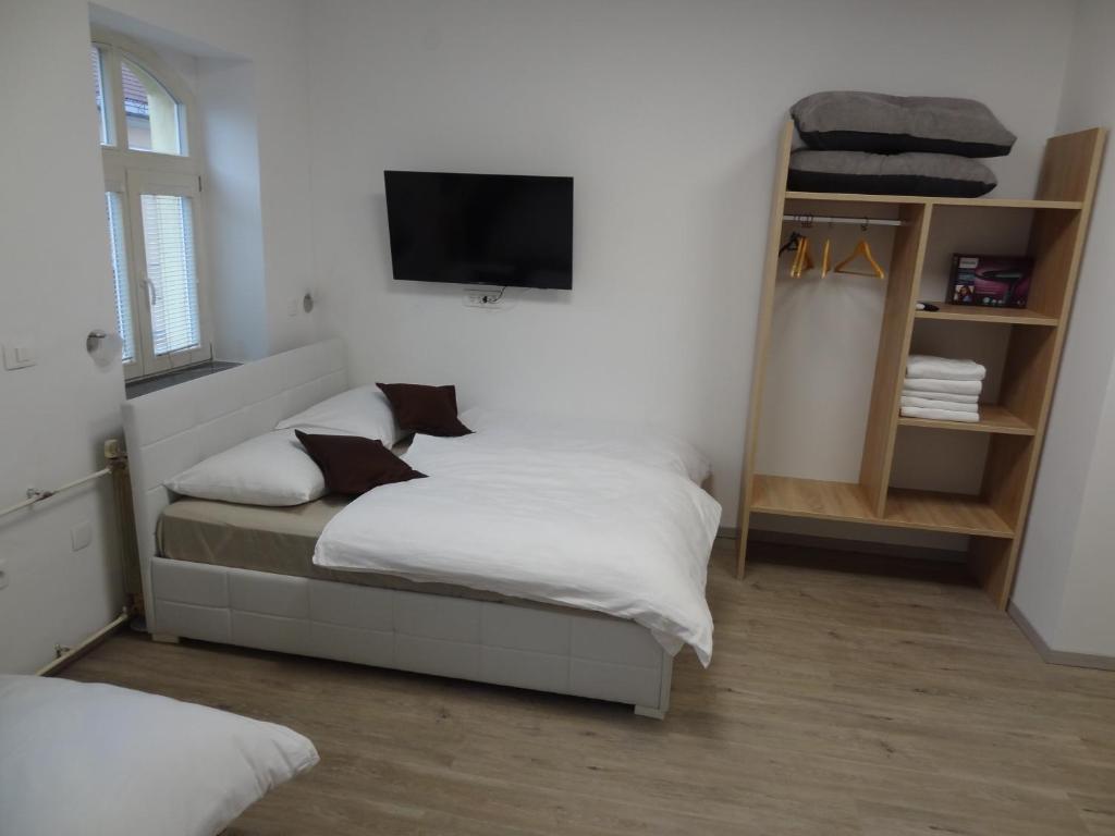 a bedroom with a bed and a flat screen tv at Tabor - Apartments Rozmanova Street in Ljubljana