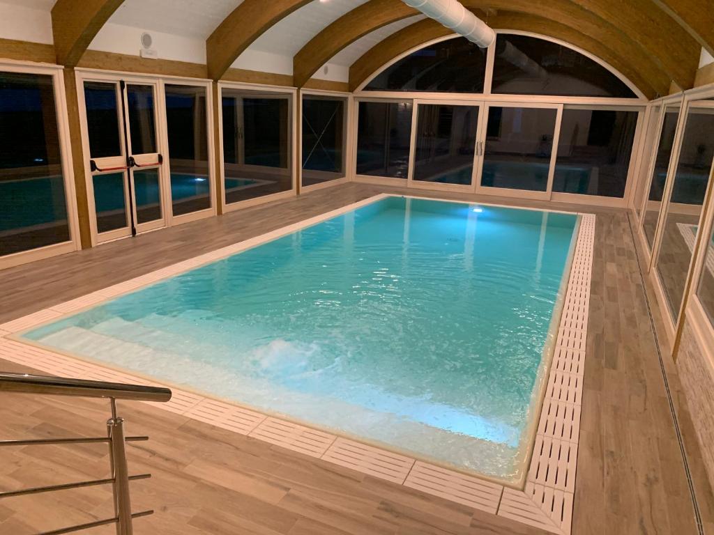 - une grande piscine dans une pièce dotée de fenêtres dans l'établissement Hotel Nuovo Parco, à Sestola