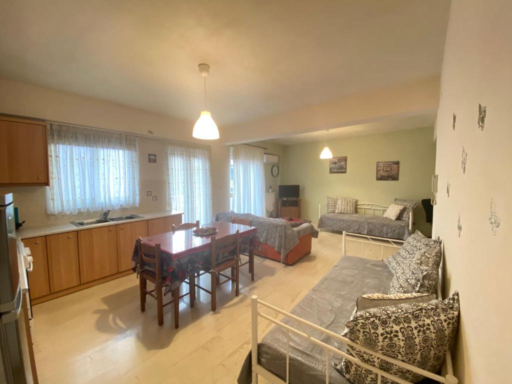 cocina y sala de estar con mesa y sofá. en Διαμέρισμα 65 τμ στην καρδιά της πόλης, en Tripolis