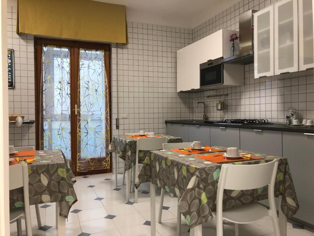 uma cozinha com mesas e cadeiras numa cozinha em B&b Il Bacio em Modugno