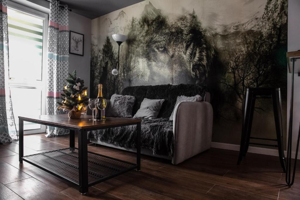 een woonkamer met een bank en een tafel bij Apartament Wataha in Ustrzyki Dolne