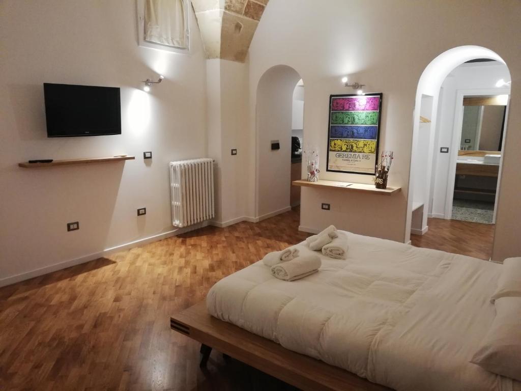 a bedroom with a white bed and a tv on the wall at Tito Schipa B&B in Lecce