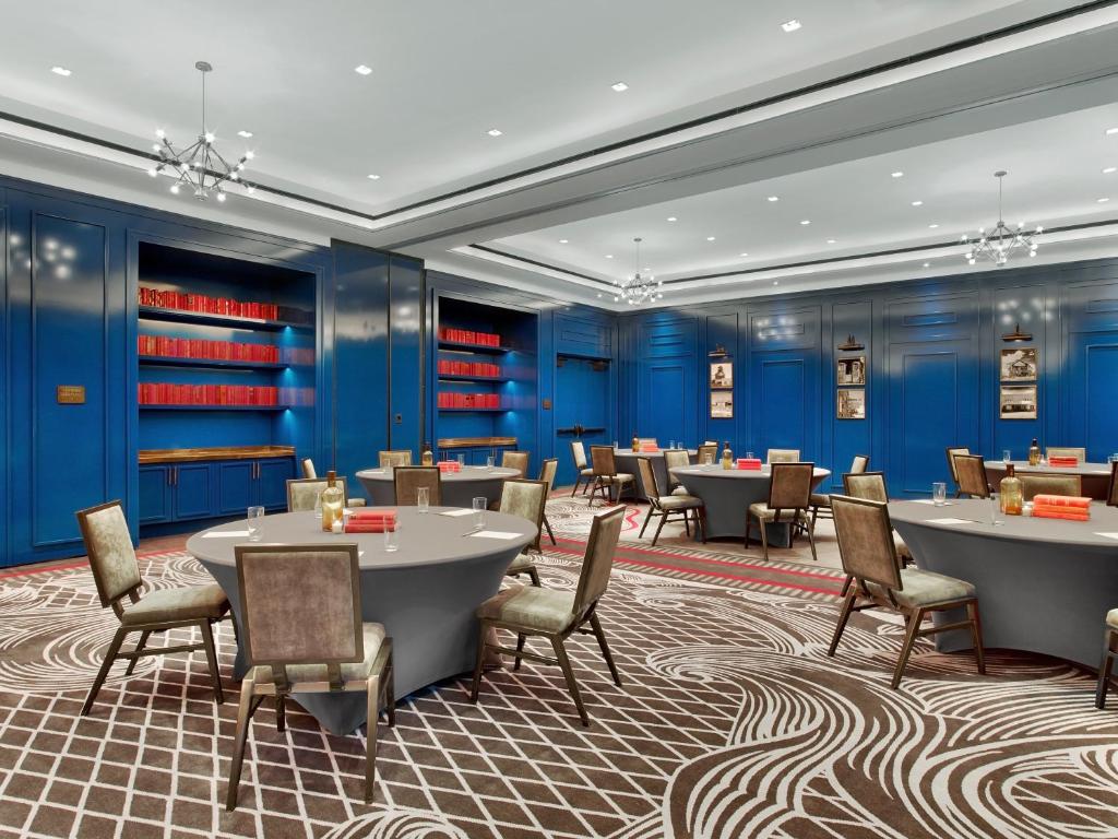 a dining room with tables and chairs and blue walls at Hotel Van Zandt in Austin
