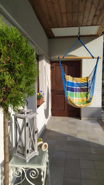 a hammock hanging on the side of a house at Várvölgy Vendégház - teljes ház, kizárólagos használattal in Veszprém