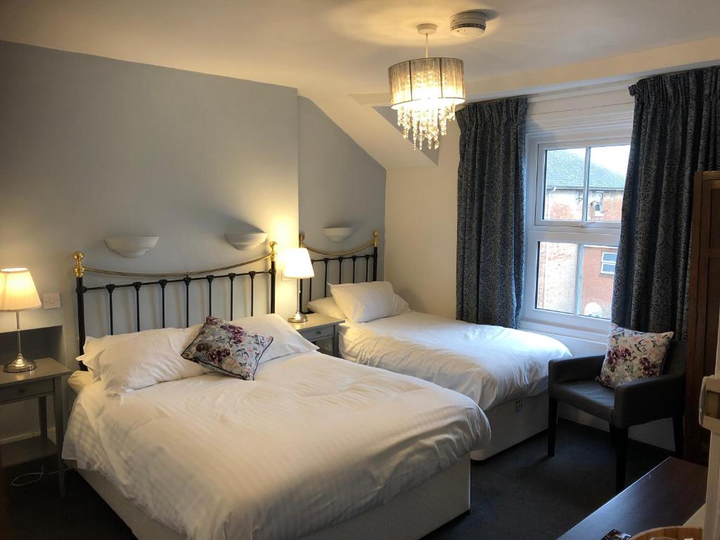 Habitación de hotel con 2 camas y ventana en Newton House Oxford, en Oxford