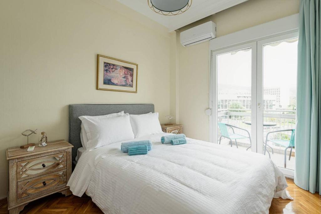 een slaapkamer met een wit bed en een balkon bij Endless View City Center Condo in Thessaloniki