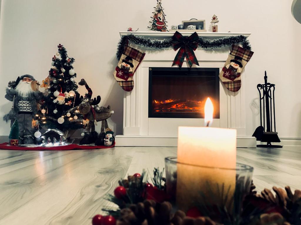 a living room with a fireplace and a christmas tree at Condmari Residential Apartament in Braşov