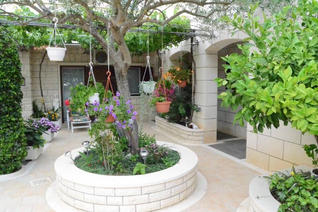 un jardín en un edificio con flores y plantas en Apartments DARIJA & PERO, en Pučišća