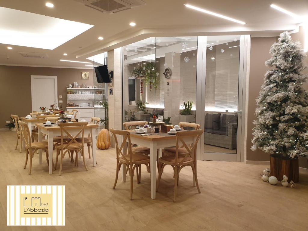 un comedor con mesas y un árbol de Navidad en B&B L'ABBAZIA, en Torre Maggiore