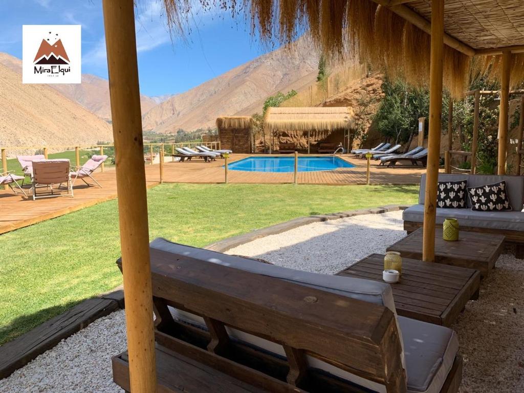 a pavilion with a bench and a swimming pool at Cabañas Miraelqui in Pisco Elqui
