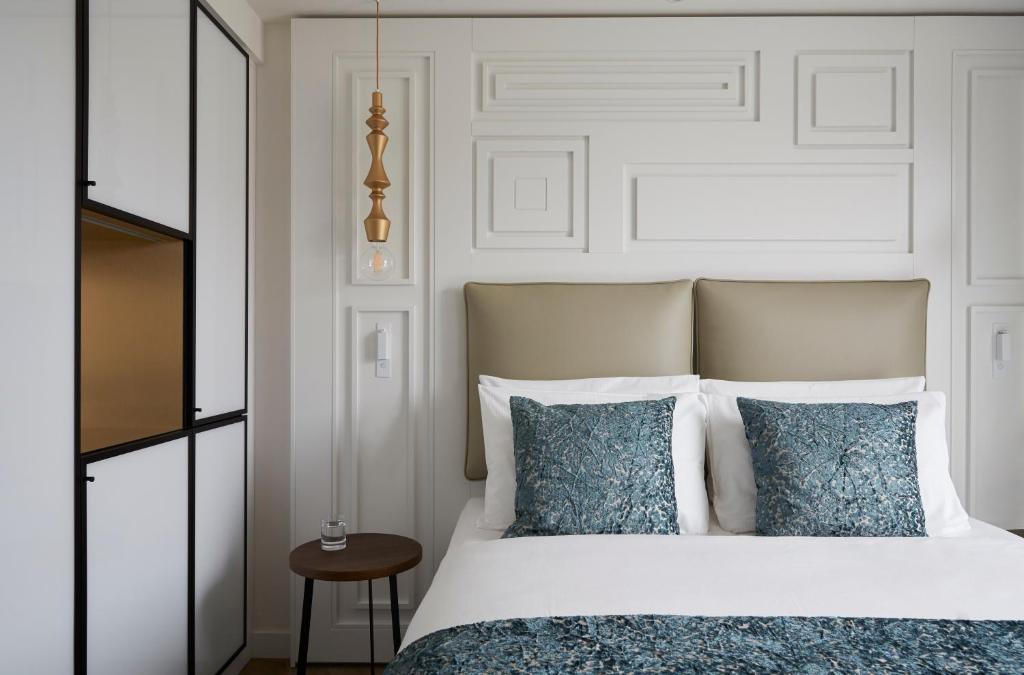 a bedroom with a white bed with blue pillows at Hotel Indigo Dresden - Wettiner Platz by IHG in Dresden