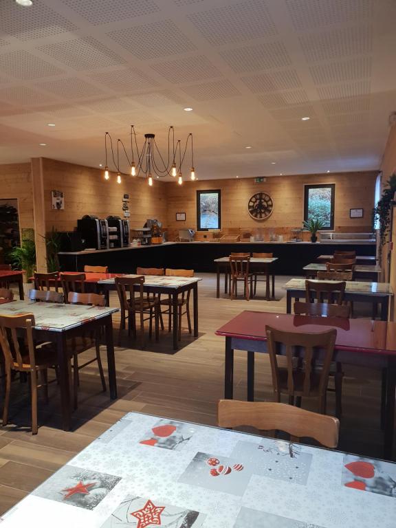 ein Speisesaal mit Tischen und Stühlen und ein Restaurant in der Unterkunft Hôtel Le Picors in Aucun
