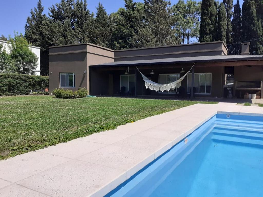 una casa con piscina frente a una casa en la casa de los pájaros en San Pedro