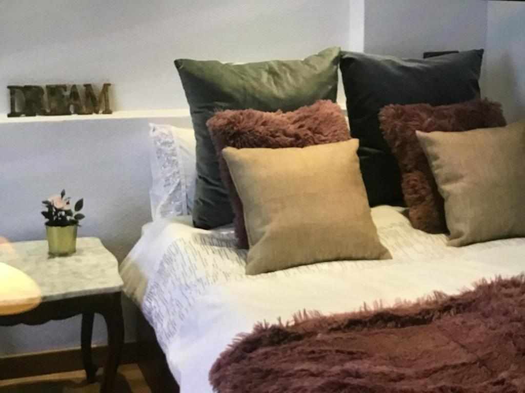 a bed with many pillows on it with a table at Apartamento with Jacuzzi & sea view in Alicante