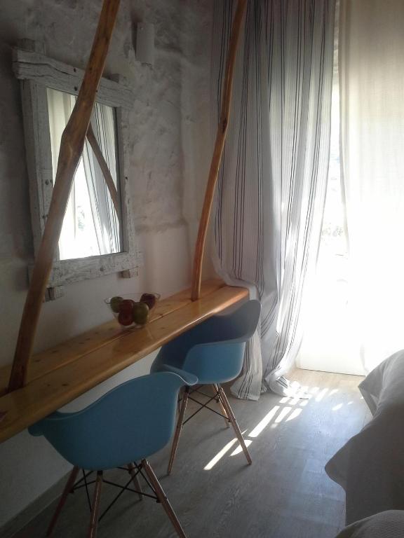 a desk in a room with two blue chairs and a window at Sea Side Studios & Houses in Kalo Livadi
