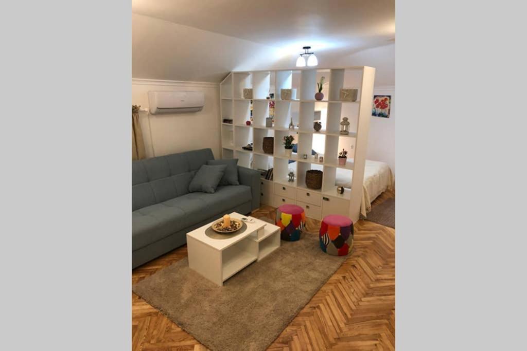 ein Wohnzimmer mit einem blauen Sofa und einem Tisch in der Unterkunft Apartman Iva in Belgrad