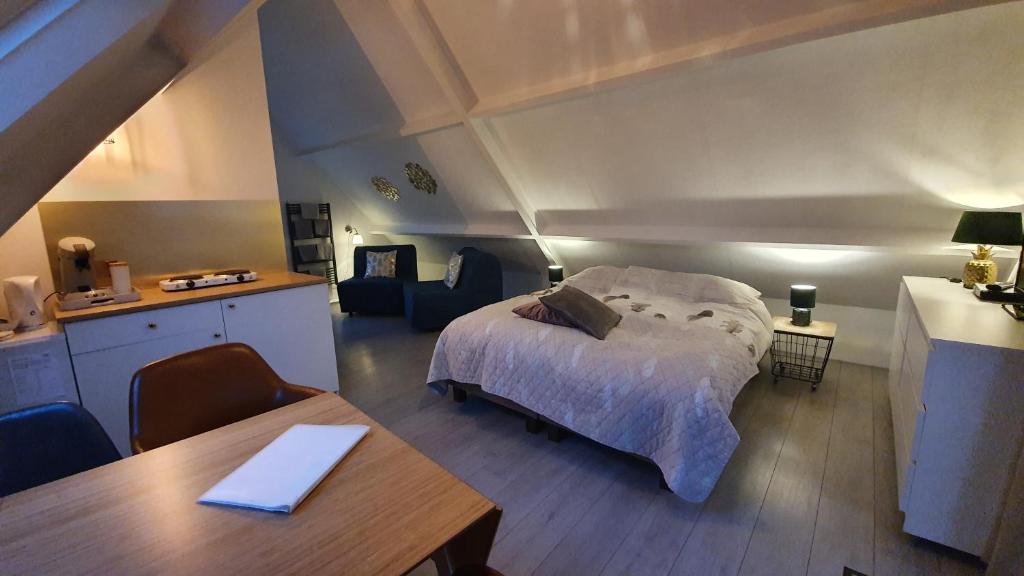 a bedroom with a bed and a table in a room at Logeren op Dijk43 in Broek op Langedijk
