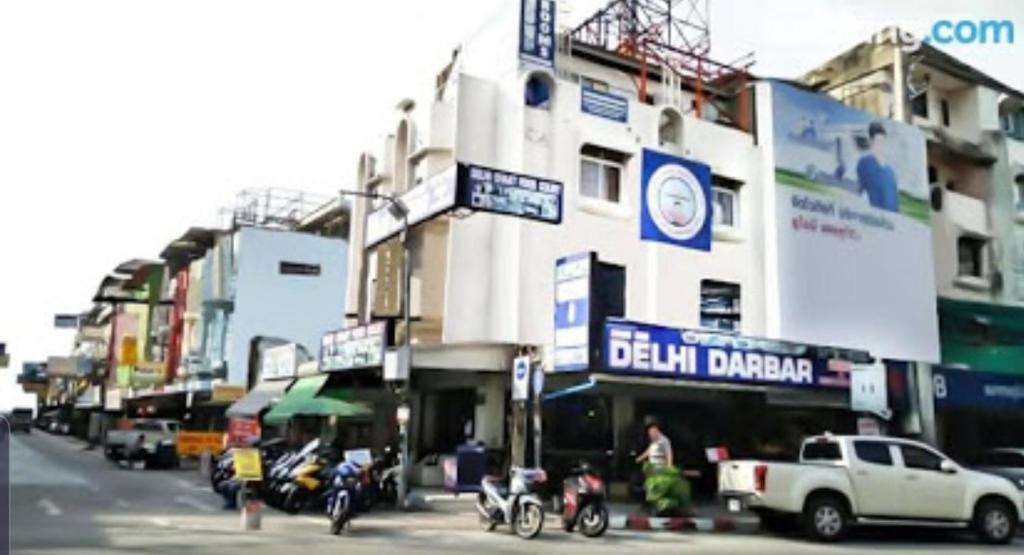 a building with motorcycles parked on the side of a street at Hari Om Delhi Darbar in Pattaya