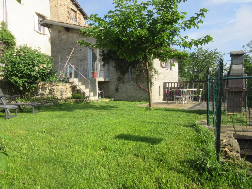 a yard in front of a house with a table at Gîte La Bodib in Fabras
