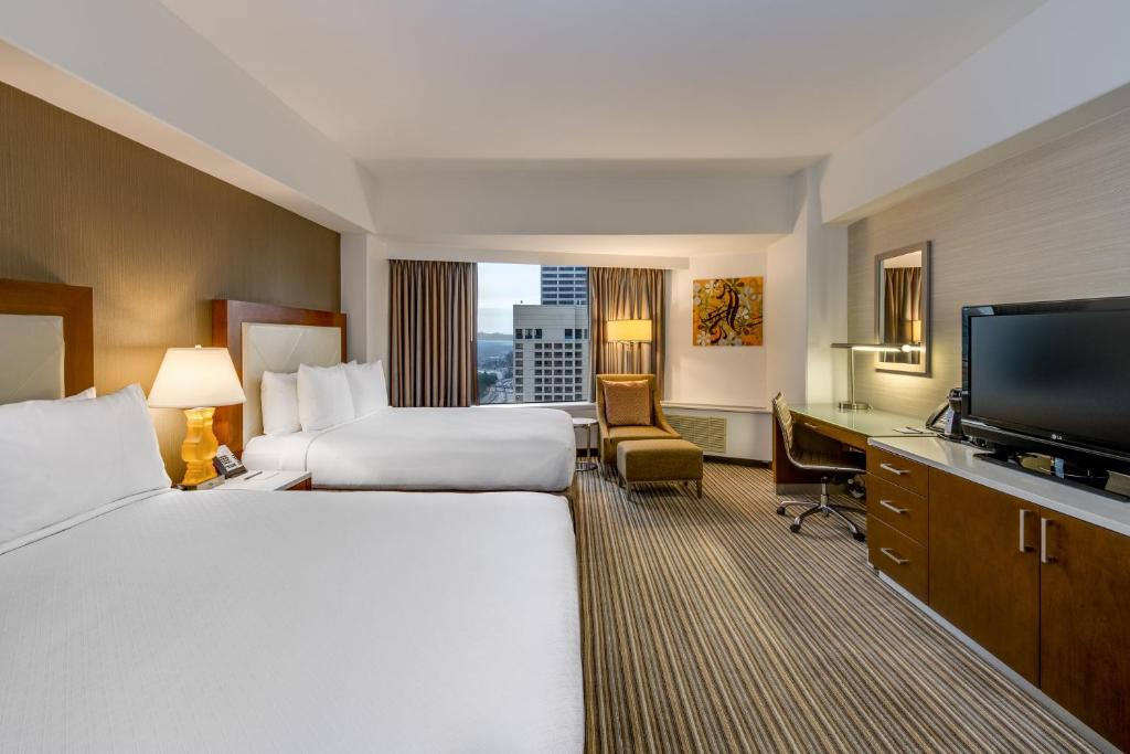 um quarto de hotel com duas camas e uma televisão de ecrã plano em Crowne Plaza Seattle, an IHG Hotel with no Resort Fee em Seattle