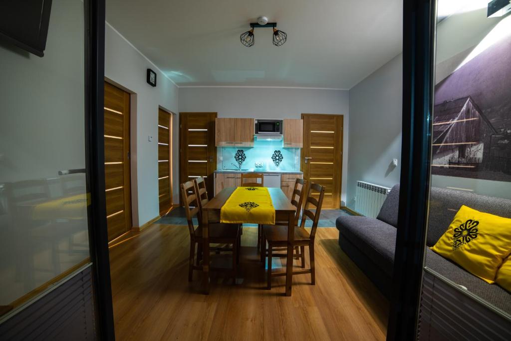 a kitchen and dining room with a table and chairs at Apartamenty Słoneczny Przystanek in Szczyrk