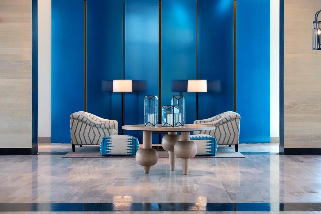 a table in a room with two chairs and a blue wall at Kimpton Seafire Resort + Spa by IHG in West Bay