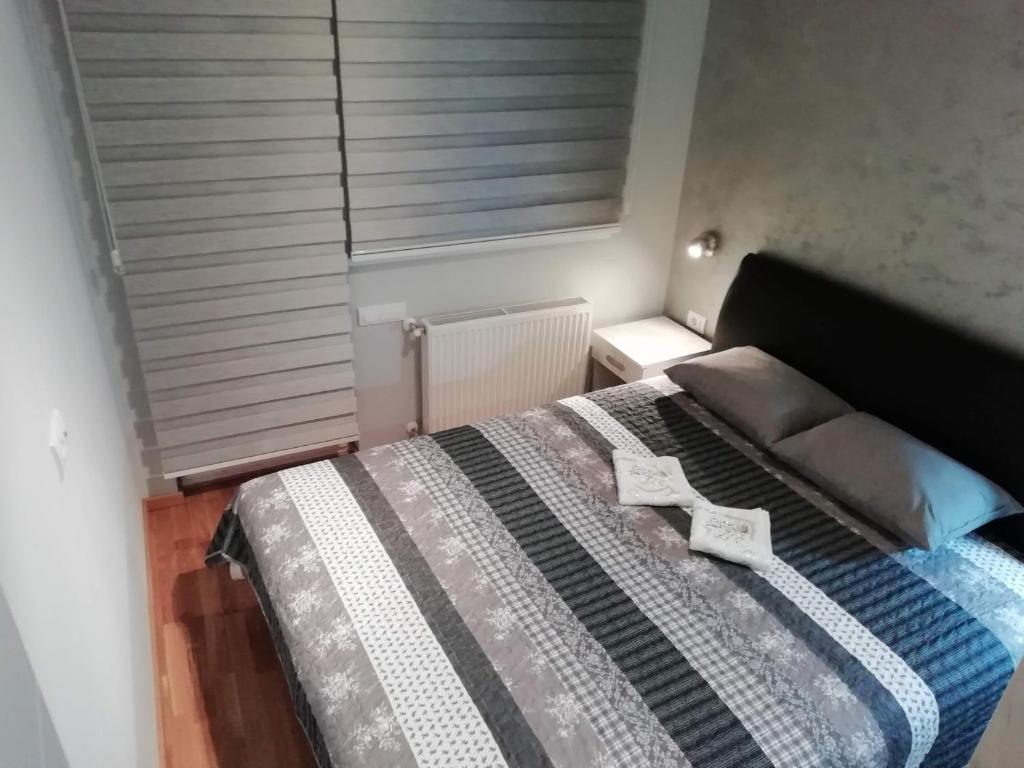 a bedroom with a bed with a black headboard and a window at ELENA LUX in Užice