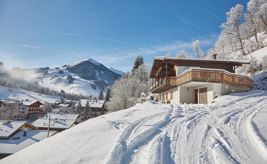 ein Haus auf einem schneebedeckten Hügel mit einer Skipiste in der Unterkunft Chalet Lodge Hubertus in Saalbach-Hinterglemm