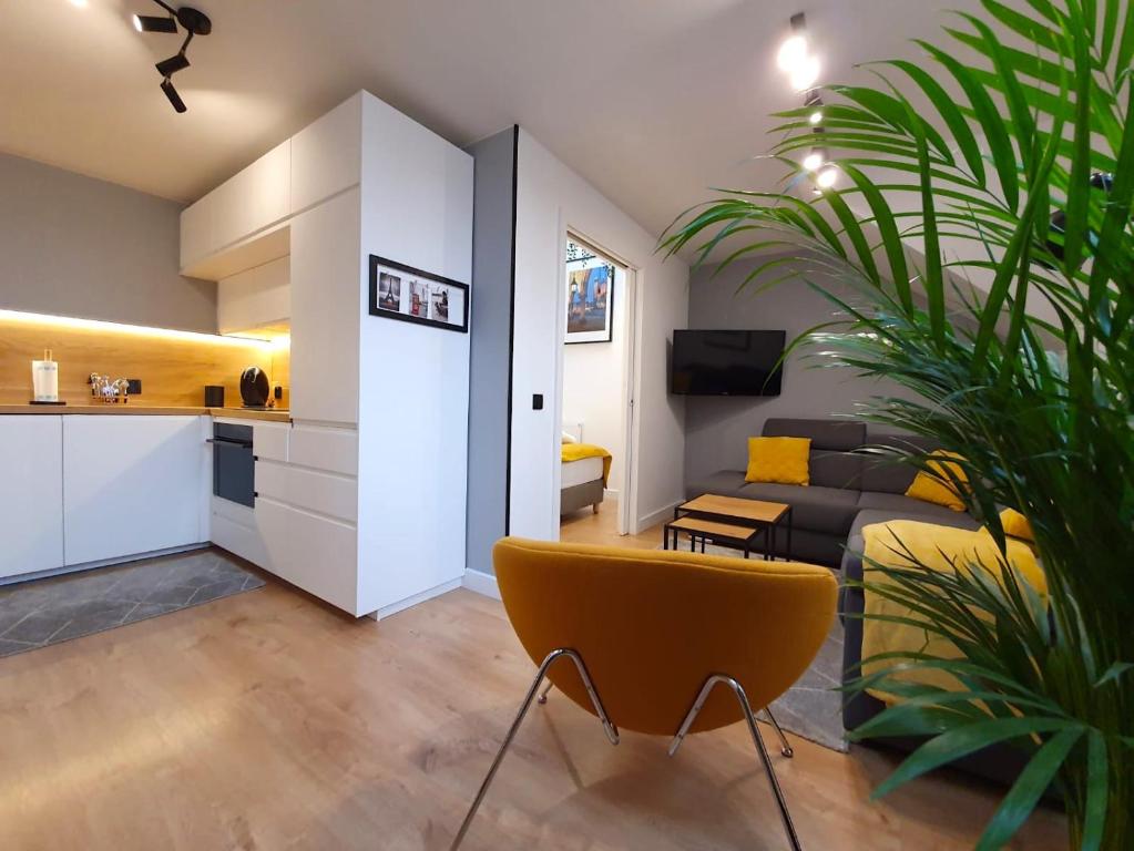 a living room with a couch and a yellow chair at Rister Apartments Dwernickiego in Krakow