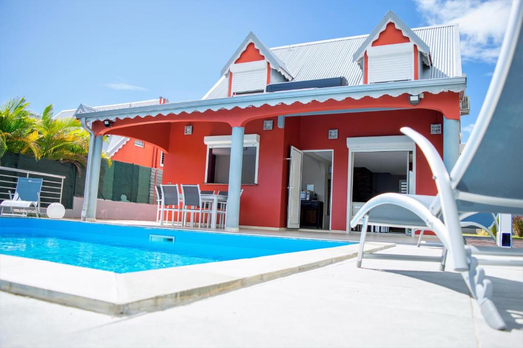 a house with a swimming pool and a red house at VILLA D'ALICE 1 in Sainte-Anne