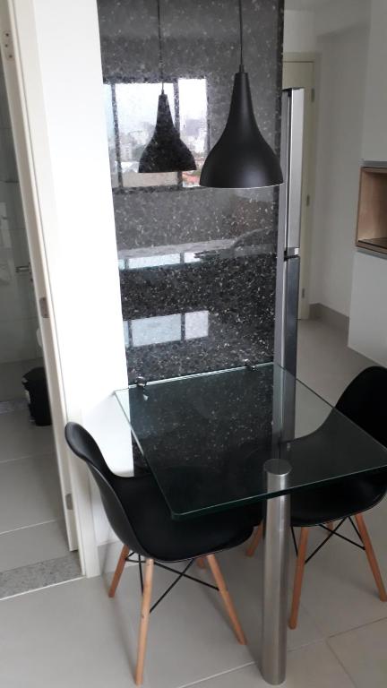 a glass table and a black chair in a kitchen at Beach Class Ilha do Leite in Recife