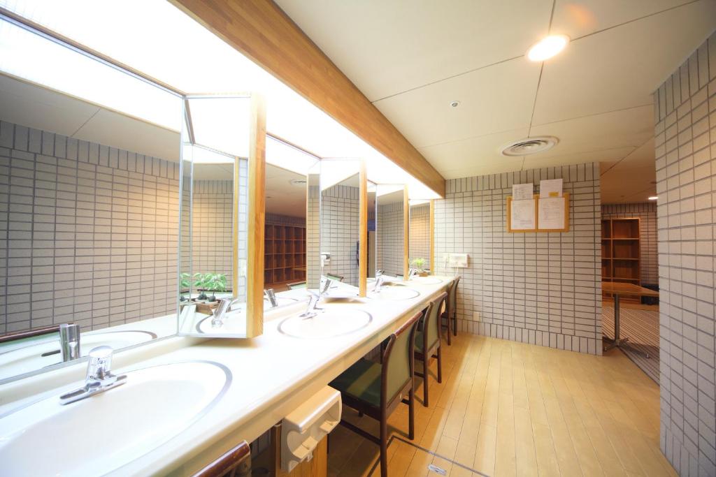 Baño con una fila de lavabos y espejos en Shiga Lake Hotel, en Yamanouchi