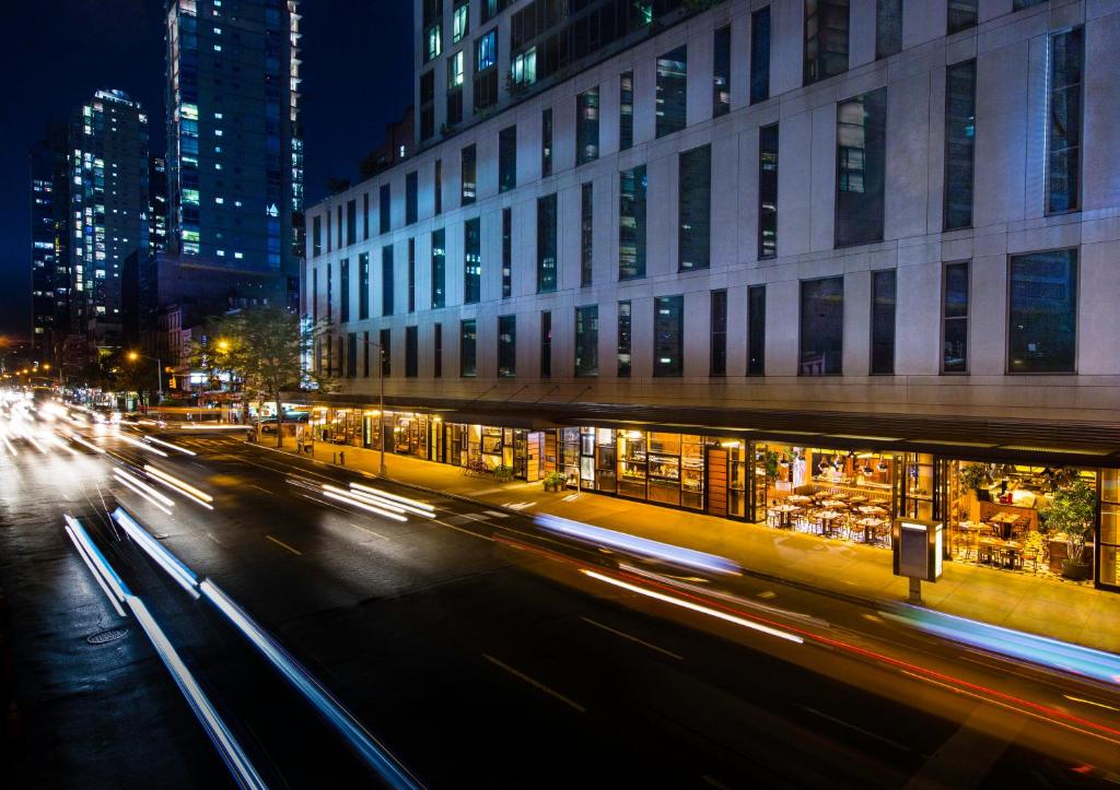 فندق Kimpton Eventi في نيويورك: شارع المدينة بالليل فيه مباني وانوار
