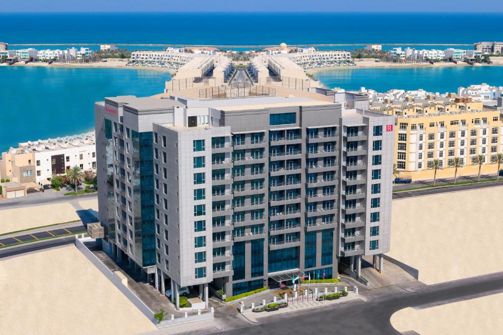 z góry widok na wysoki budynek z wodą w obiekcie Ramada Hotel and Suites Amwaj Islands w mieście Manama