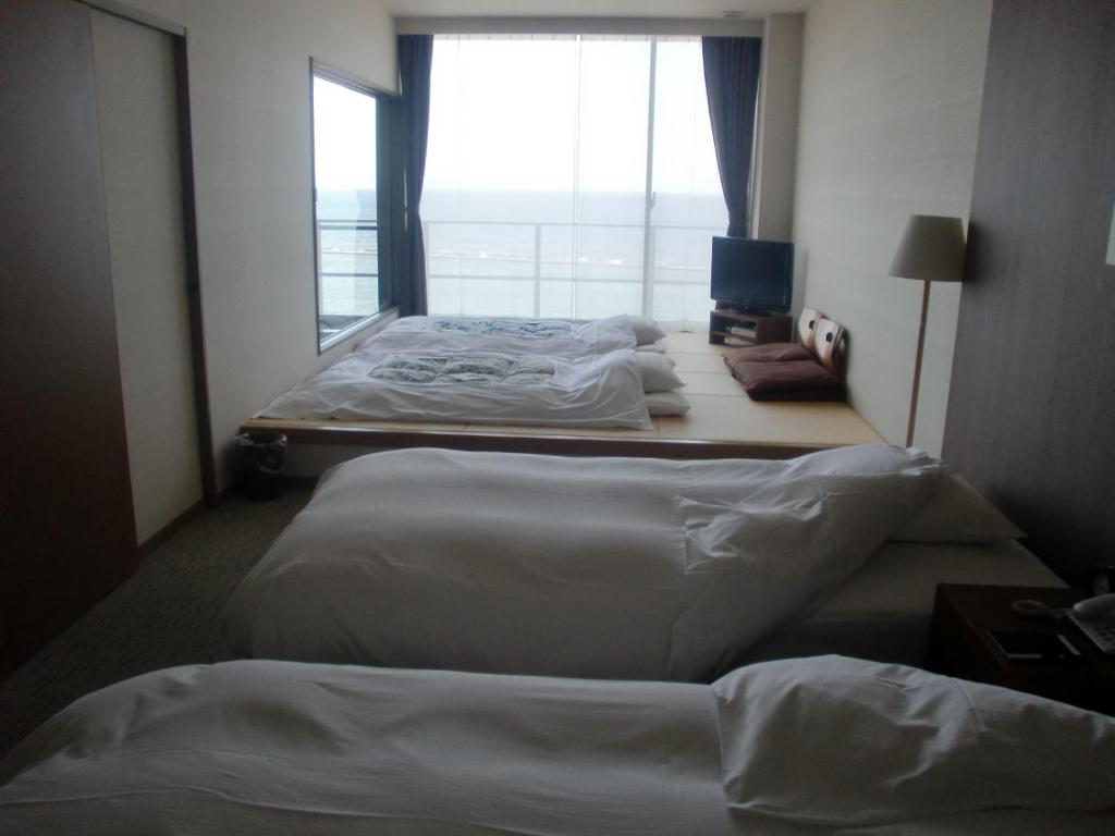 Postel nebo postele na pokoji v ubytování Bayside Square Kaike Hotel