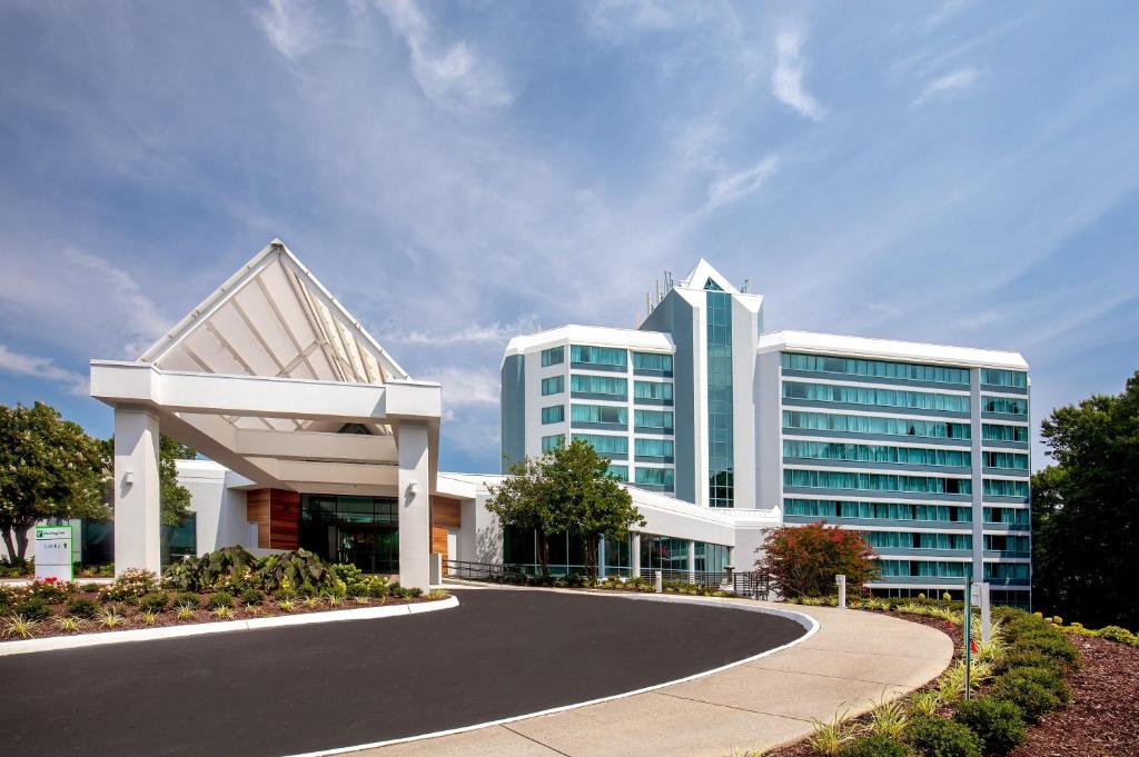 un grand bâtiment de bureau avec une allée incurvée dans l'établissement Holiday Inn Newport News - Hampton, an IHG Hotel, à Newport News