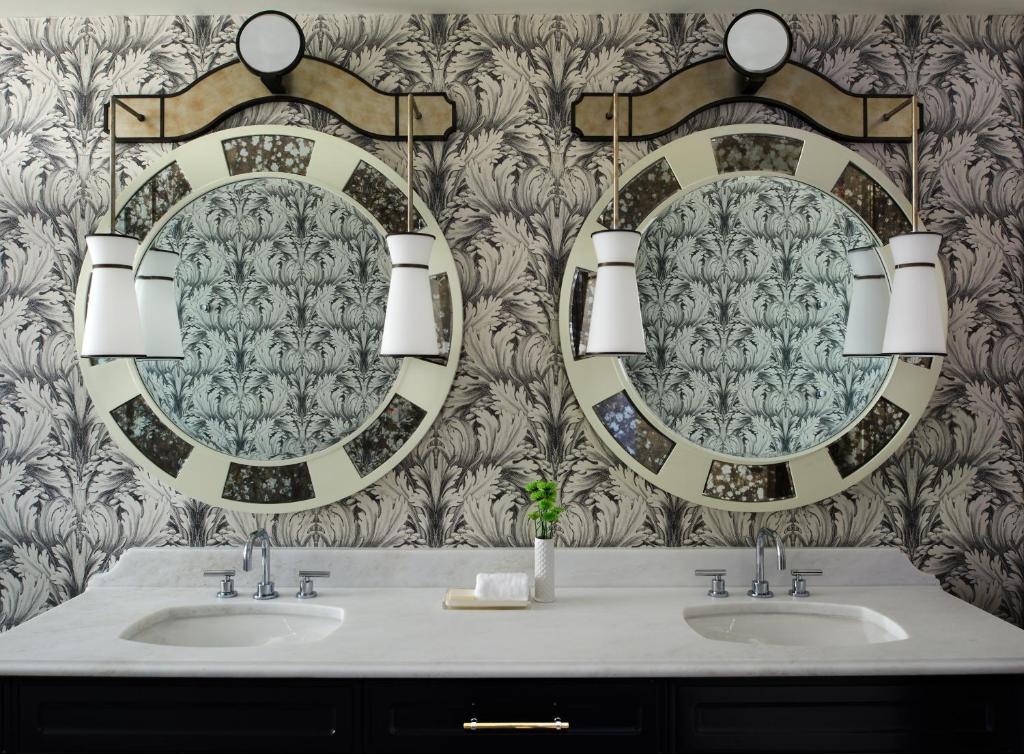 a bathroom with two sinks and two mirrors at Kimpton Hotel Monaco Washington DC, an IHG Hotel in Washington, D.C.