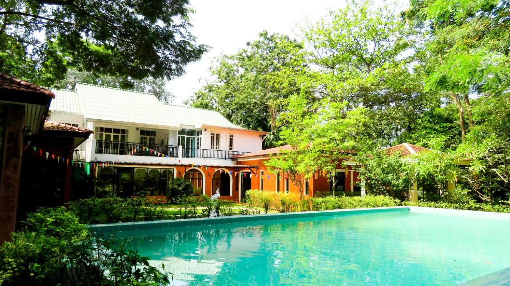 una casa con piscina frente a una casa en The Journey House Lifestyle Boutique Hotel, en Kanchanaburi