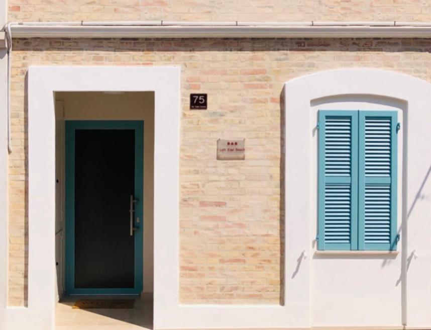 eine Tür und ein Fenster auf einem Backsteingebäude in der Unterkunft B&B LOFT EDEL BEACH in Civitanova Marche