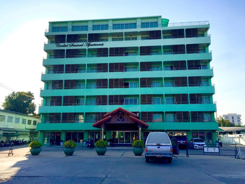 ein blaues Gebäude mit einem Van davor in der Unterkunft Cordial serviced apartment in Hua Hin